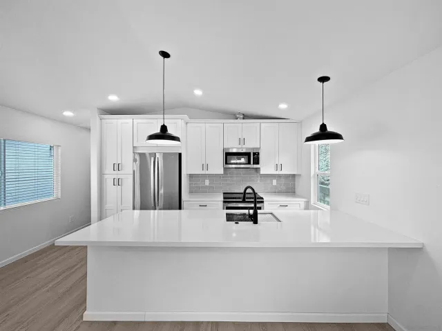 a kitchen with stainless steel appliances a kitchen island sink refrigerator and microwave