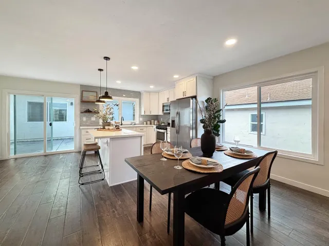 a kitchen with a dining table chairs and refrigerator