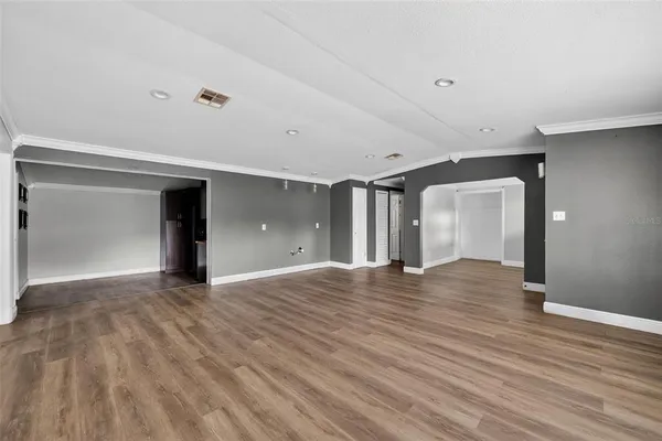 a view of an empty room with wooden floor and closet
