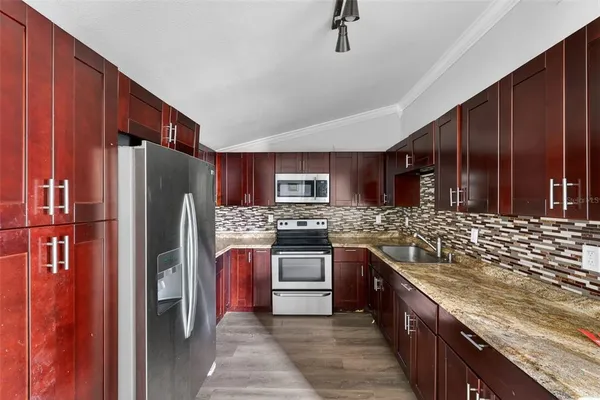 a kitchen with stainless steel appliances granite countertop a refrigerator and a stove