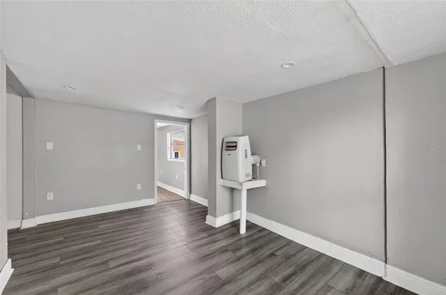 a view of empty room with wooden floor