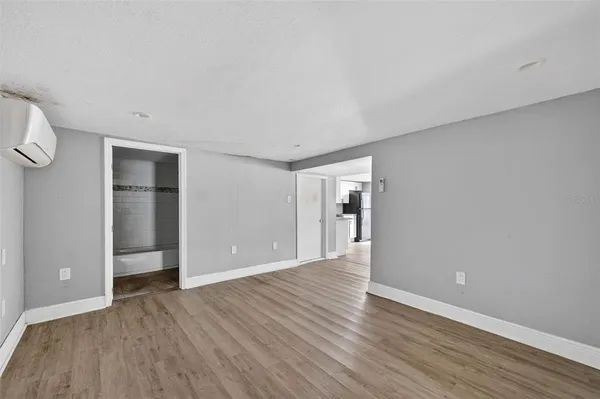 a view of an empty room with wooden floor and closet