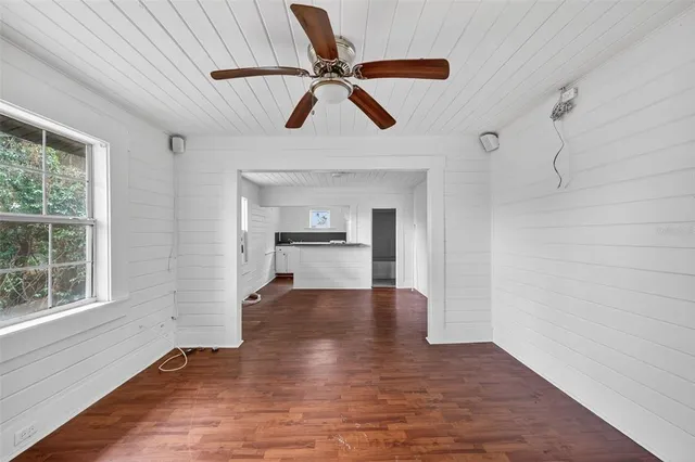 a view of empty room with wooden floor and ceiling fan