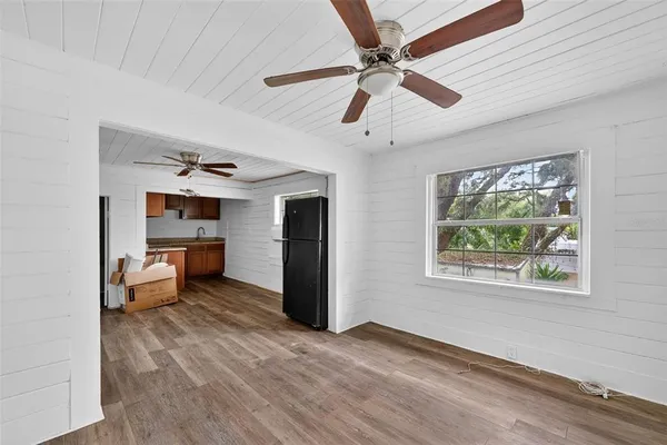 a view of a livingroom with a flat screen tv ceiling fan and window