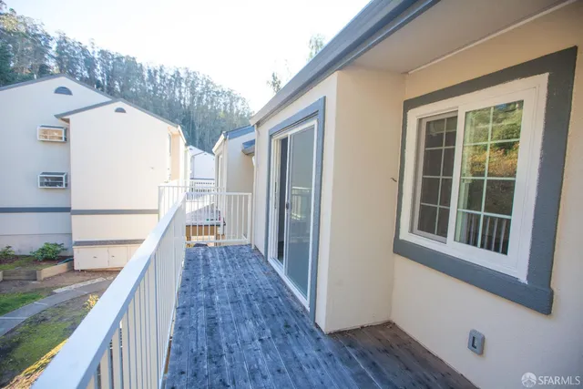 a view of a balcony with wooden floor and fence