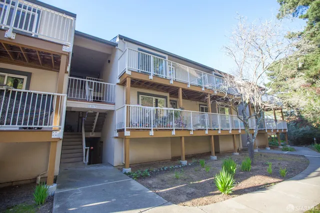 a front view of a building with a garden and plants