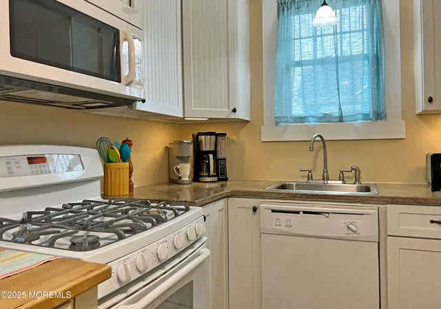 a kitchen with stainless steel appliances granite countertop a sink stove and cabinets