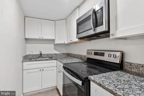 a kitchen with a sink stove and cabinets