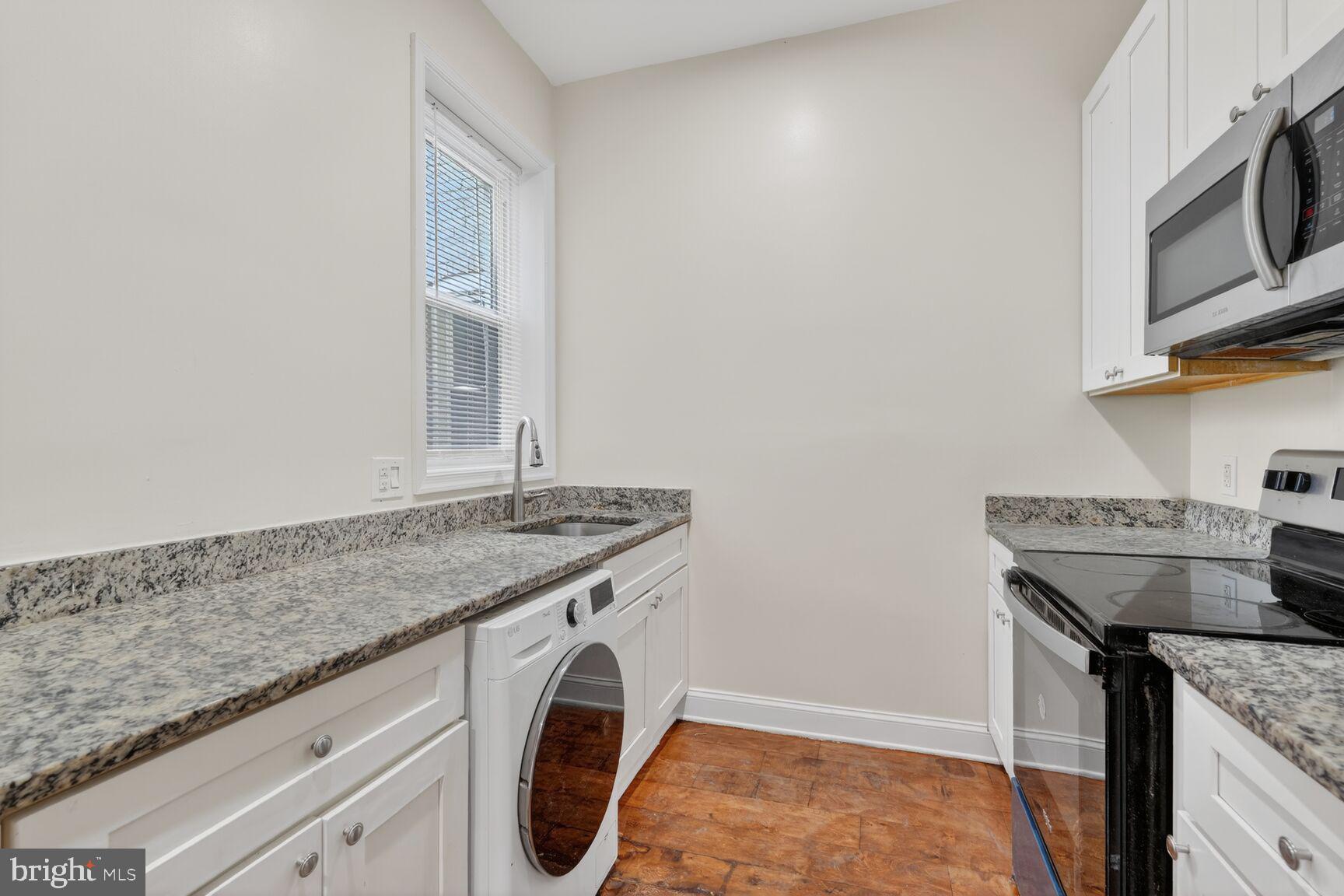 113 15th Street Southeast Washington, DC 20003 - Photo 6 of 27 a utility room with granite countertop cabinets washer and dryer