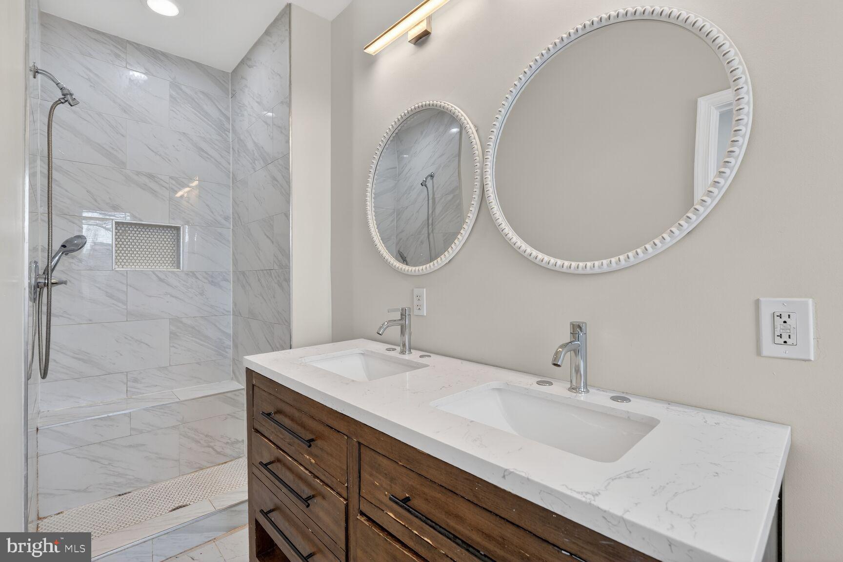113 15th Street Southeast Washington, DC 20003 - Photo 10 of 27 a bathroom with a granite countertop double vanity sink and a mirror