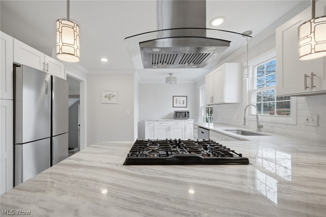 3722 Lindholm Road Shaker Heights, OH 44120 - Photo 14 of 34 The kitchen features white cabinetry, a gas stovetop on a marble-style countertop, a stainless steel refrigerator, and a stainless steel range hood