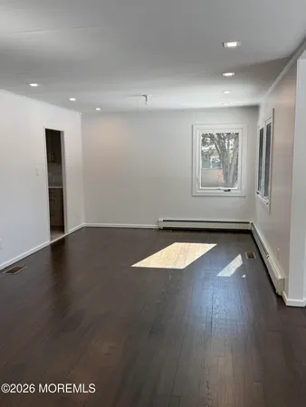 a view of a room with wooden floor and window