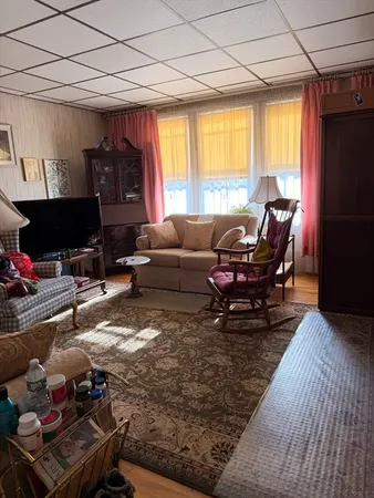 a living room with furniture a window and a flat screen tv