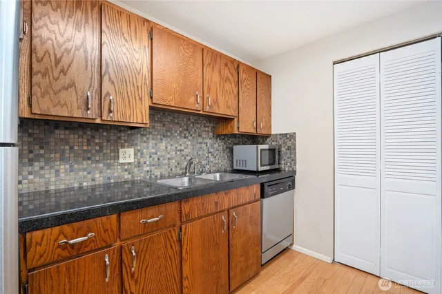 a kitchen with granite countertop wooden cabinets and white appliances