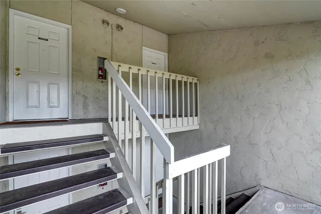 a view of staircase with lots of frames on wall and a window