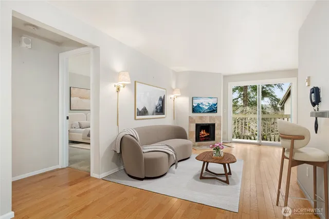 a living room with furniture a fireplace and a large window