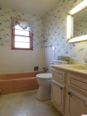 a bathroom with a sink a toilet and mirror