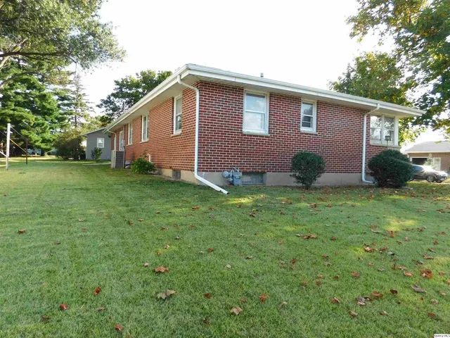 a view of a backyard with potted plants and large trees