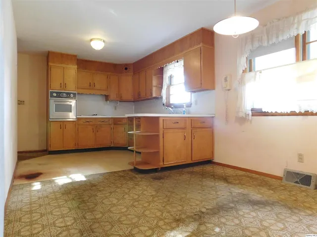 a room with kitchen island stainless steel appliances a sink and cabinets