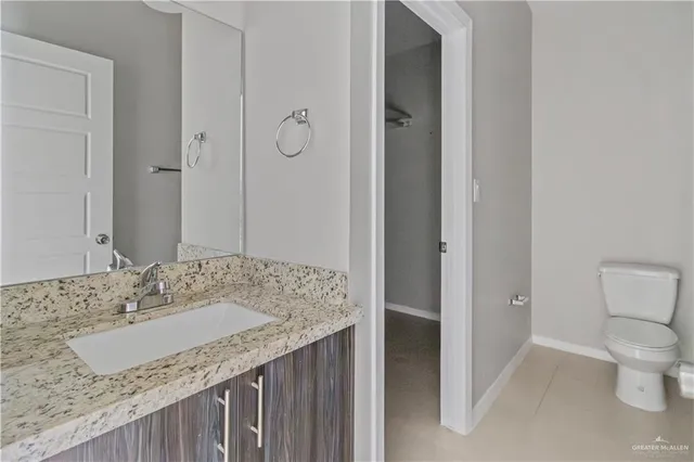 a bathroom with a granite countertop sink a toilet and shower