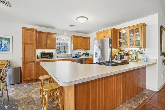 a large kitchen with stainless steel appliances a large counter top