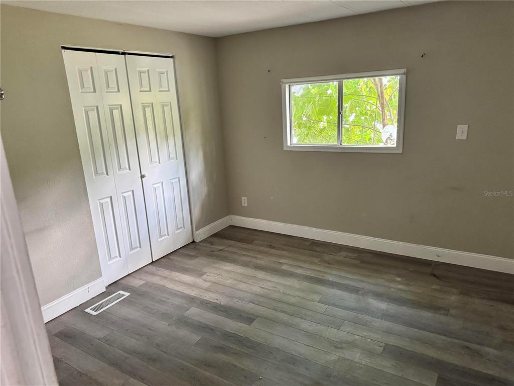 3402 Pearson Road Valrico, FL 33596 - Photo 12 of 24 an empty room with wooden floor and windows