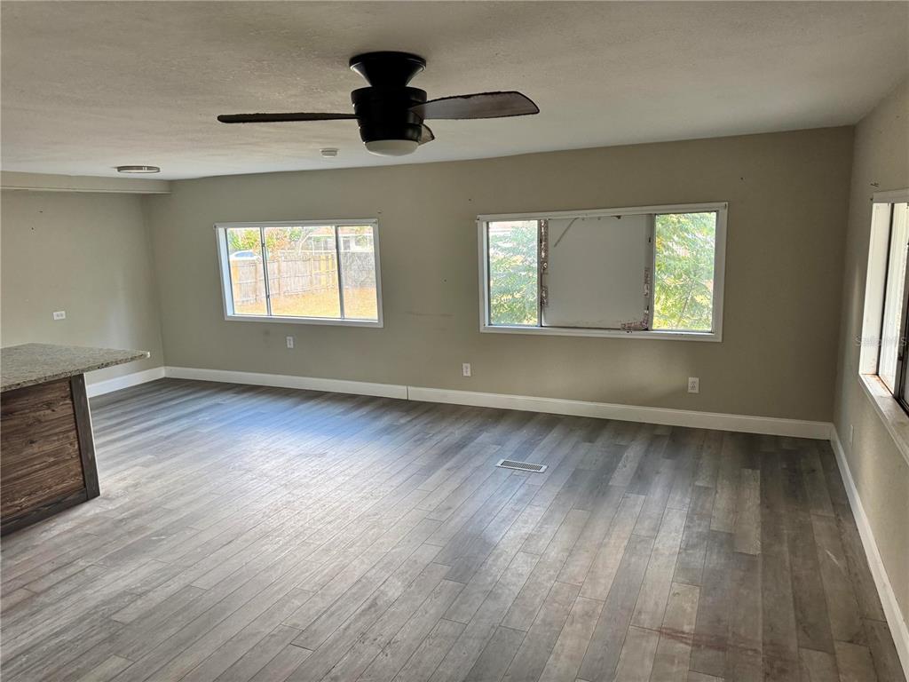 3402 Pearson Road Valrico, FL 33596 - Photo 4 of 24 an empty room with wooden floor and windows