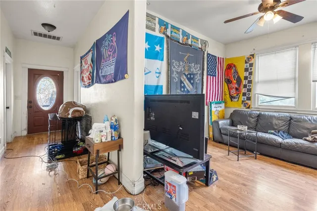 a living room with furniture a window and wooden floor