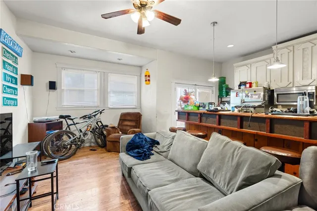 a living room with furniture kitchen area and a window