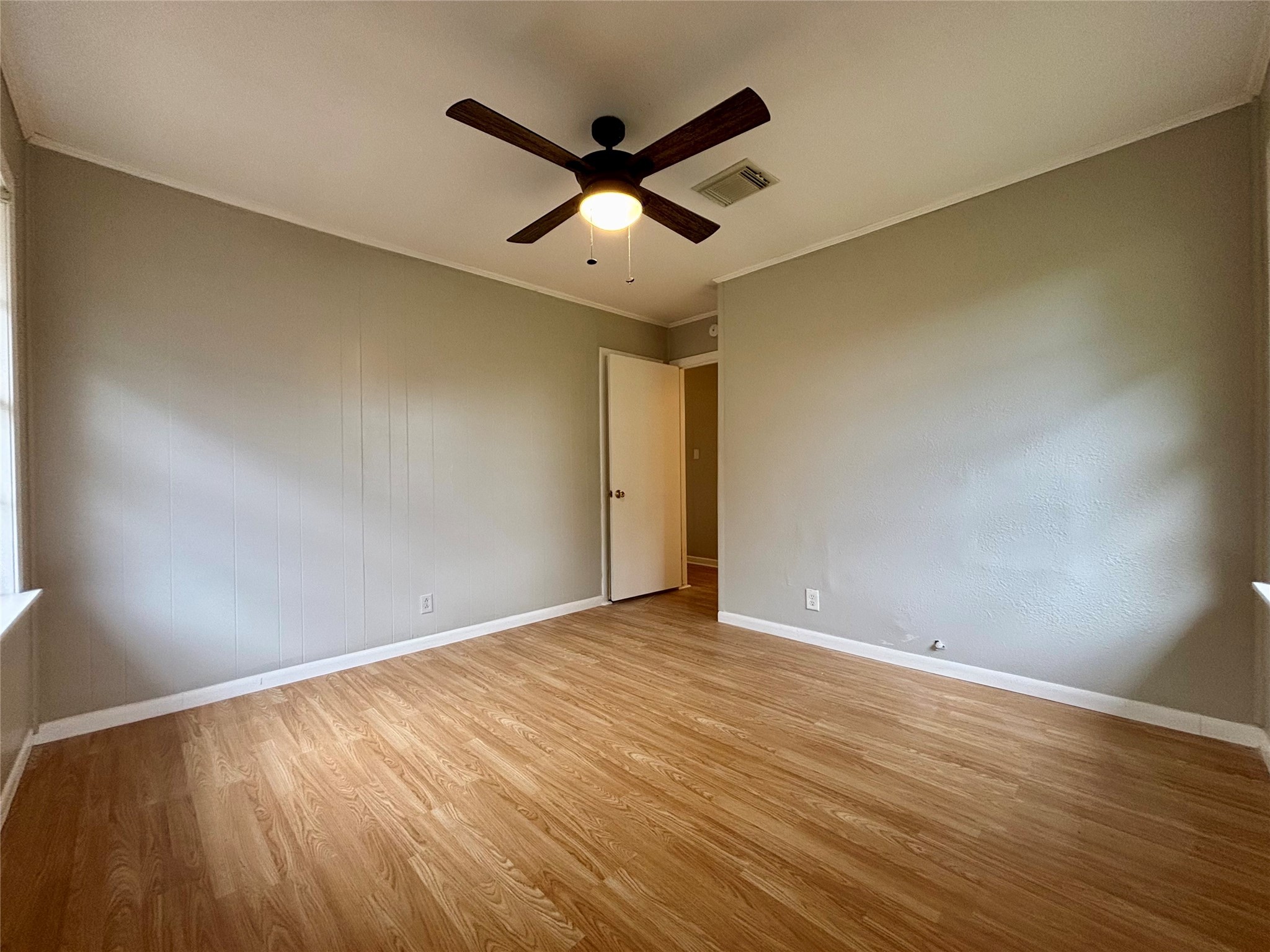 706 West 7th Street Freeport, TX 77541 - Photo 11 of 22 a view of an empty room with wooden floor and a ceiling fan