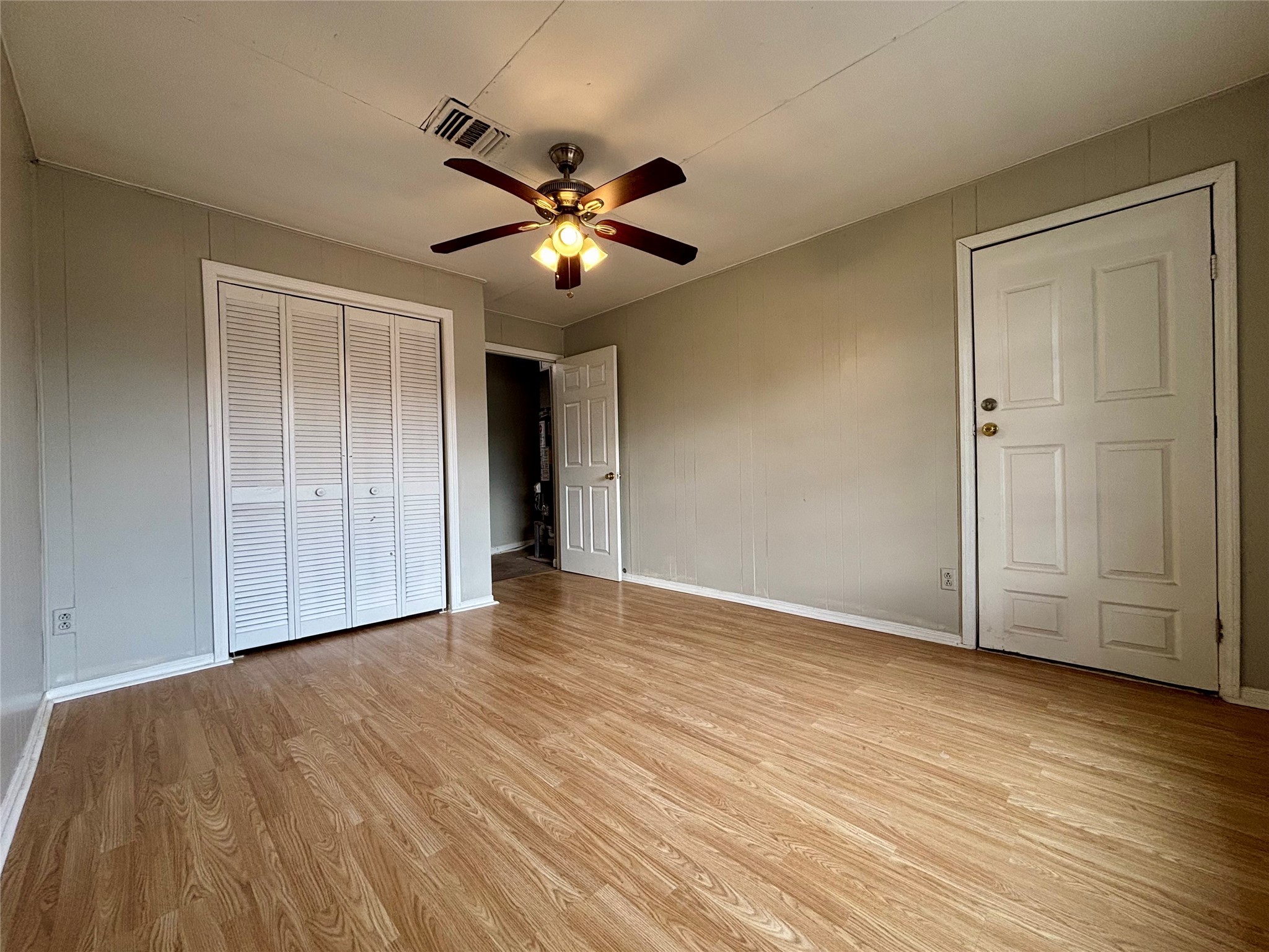706 West 7th Street Freeport, TX 77541 - Photo 15 of 22 a view of an empty room with wooden floor and a ceiling fan