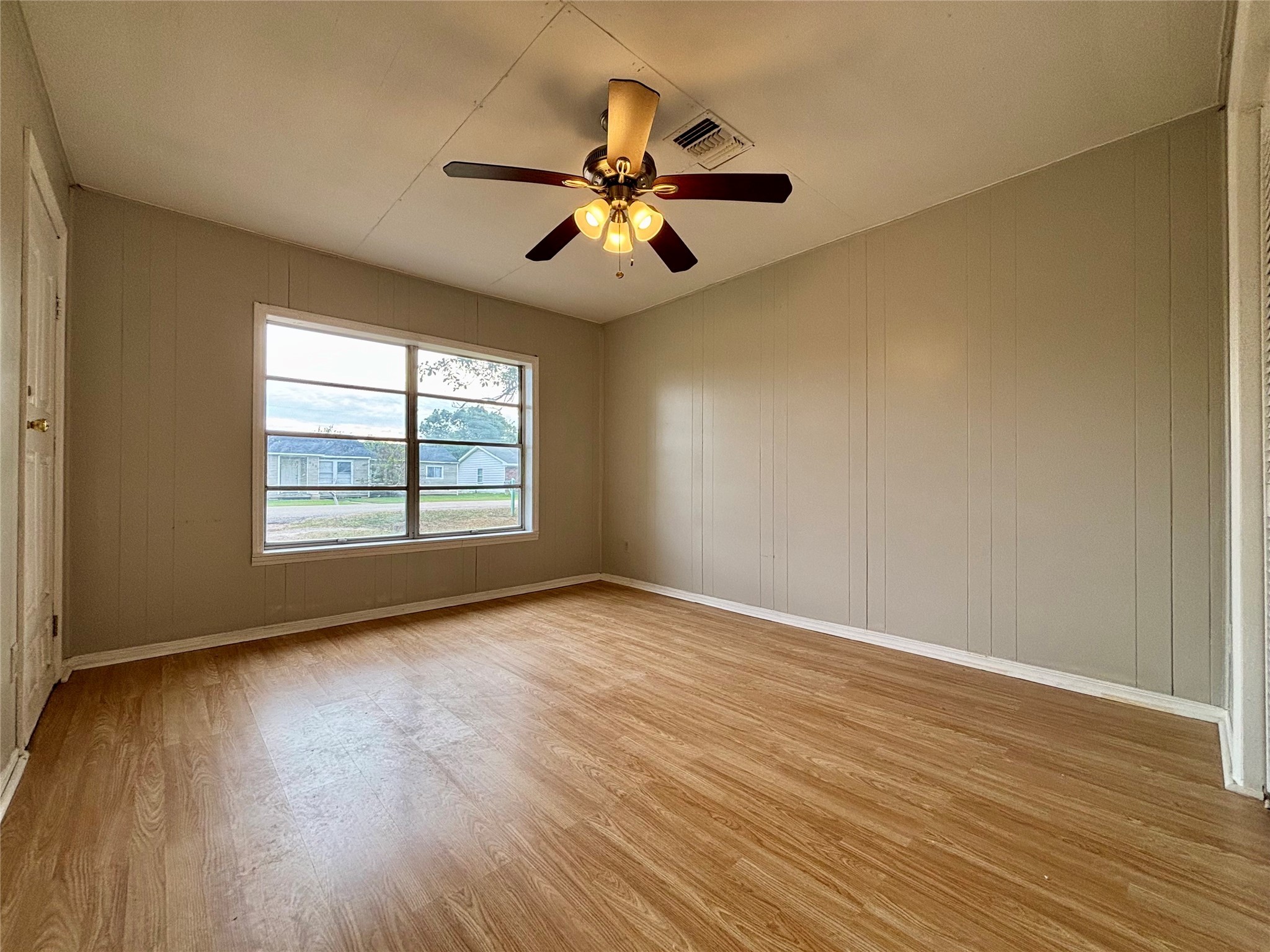 706 West 7th Street Freeport, TX 77541 - Photo 19 of 22 an empty room with wooden floor chandelier fan and windows