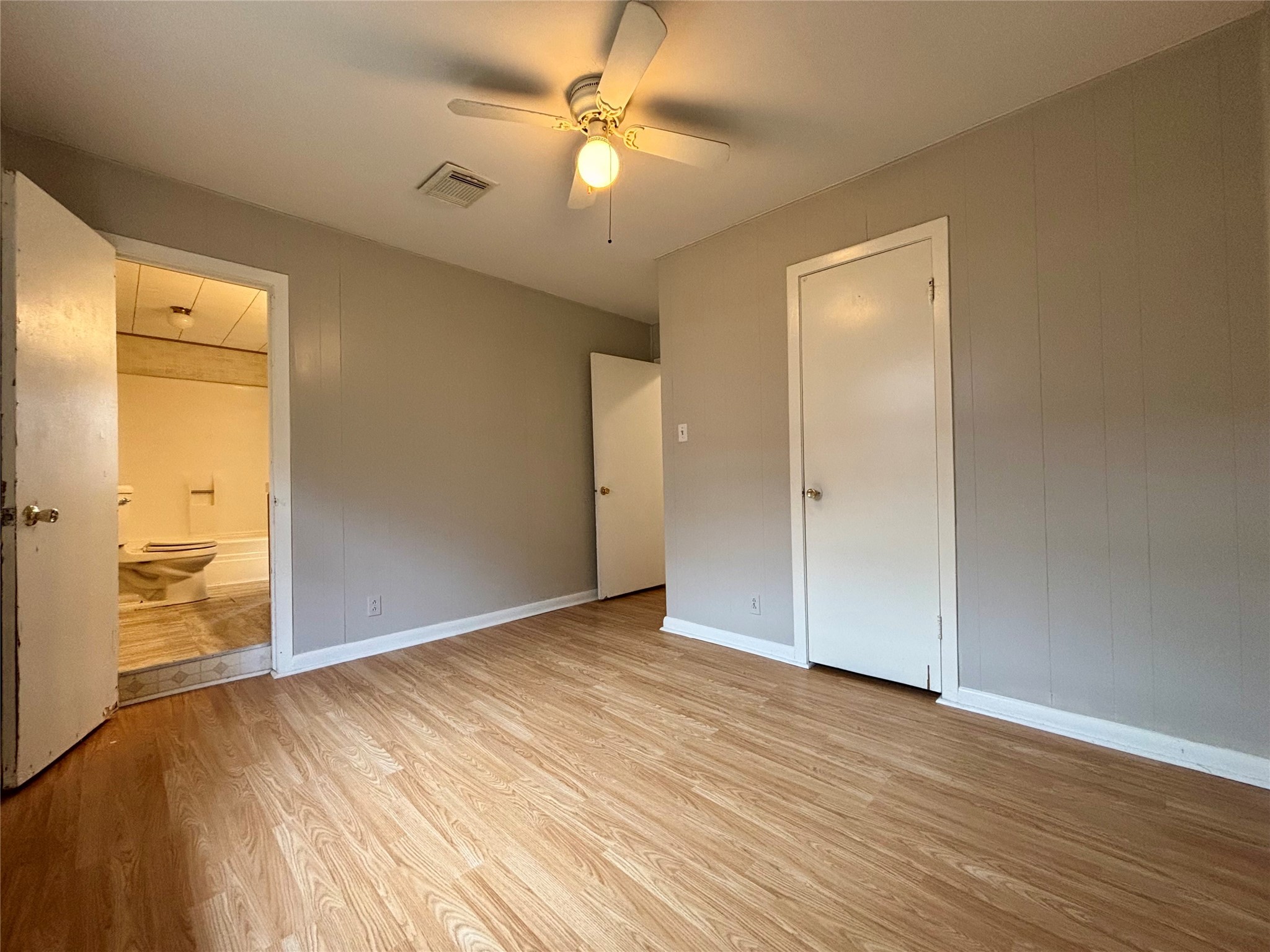 706 West 7th Street Freeport, TX 77541 - Photo 9 of 22 an empty room with wooden floor and bathroom view