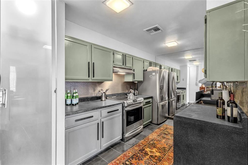 145 15th Street Northeast, Unit 409 Atlanta, GA 30361 - Photo 5 of 23 a kitchen with stainless steel appliances granite countertop a refrigerator stove and sink
