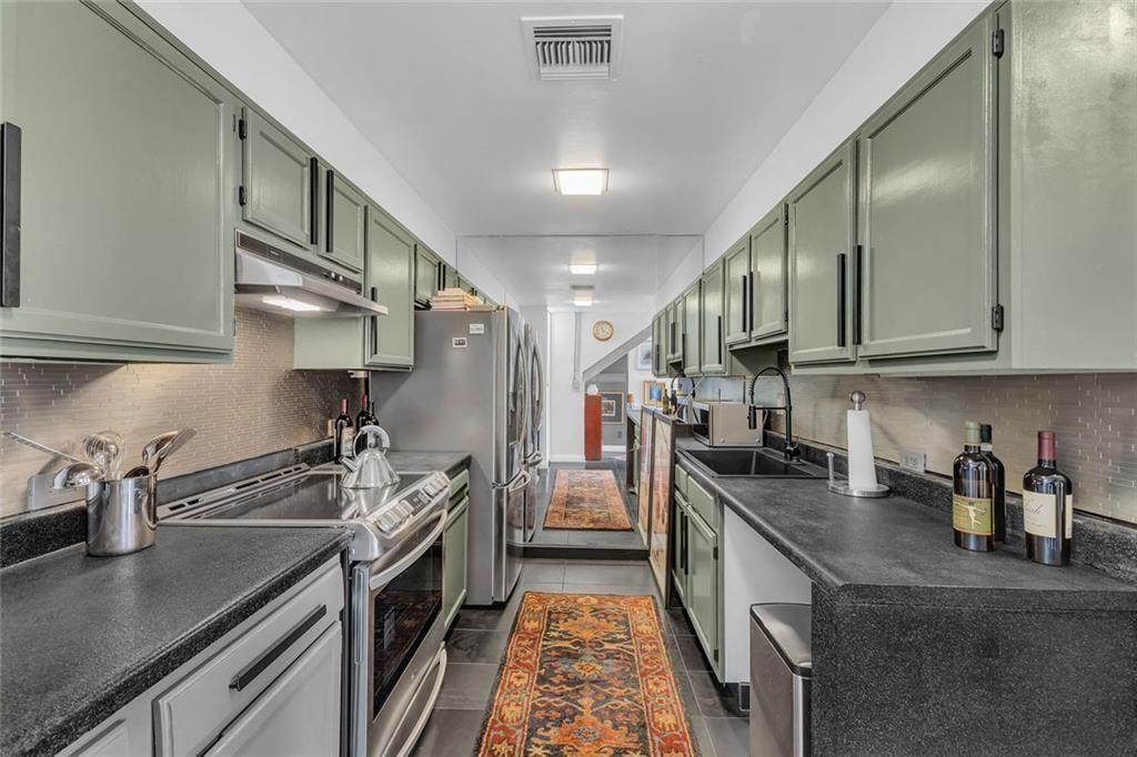 145 15th Street Northeast, Unit 409 Atlanta, GA 30361 - Photo 6 of 23 a kitchen with stainless steel appliances granite countertop a sink a stove and a refrigerator