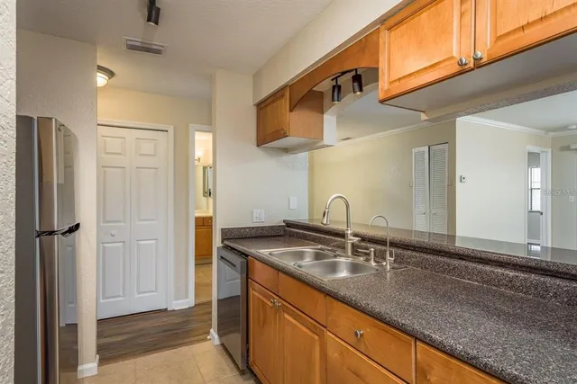 a kitchen with stainless steel appliances granite countertop a sink and a refrigerator