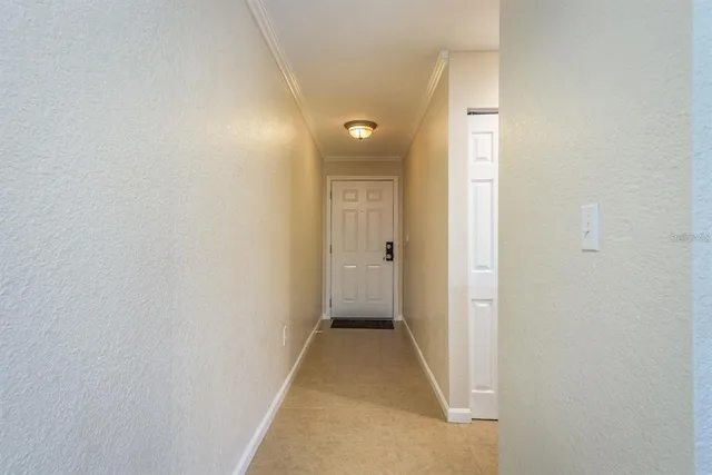 a view of a hallway with wooden floor and a bathroom