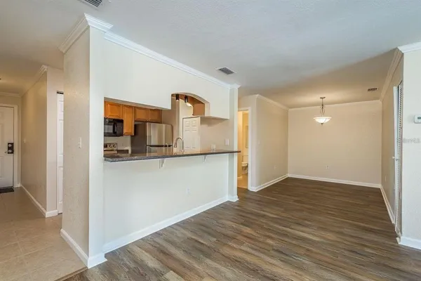 a view of a kitchen with wooden floor and a refrigerator