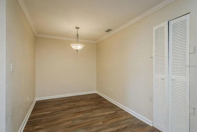 a view of a room with wooden floor and chandelier