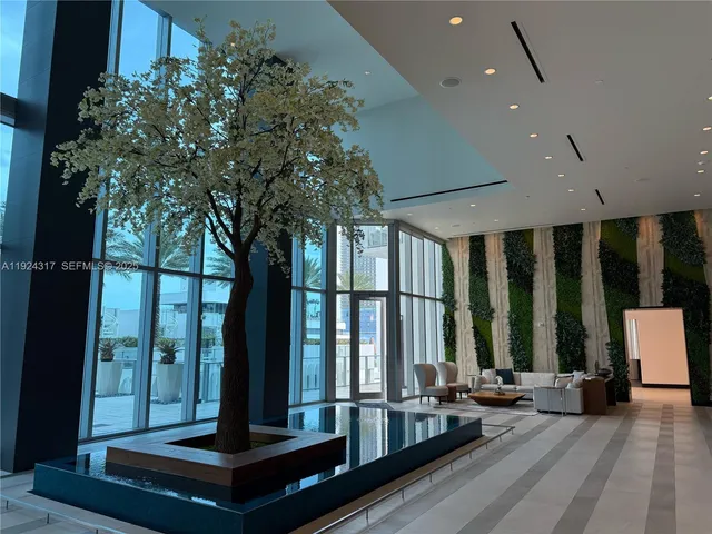 a living room with furniture and large windows