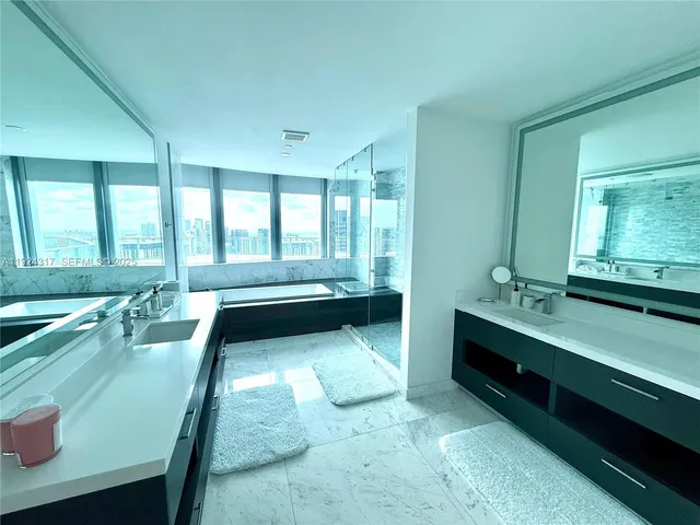 a bathroom with a tub sink and mirror