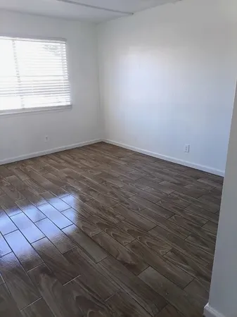a view of a room with wooden floor and a window