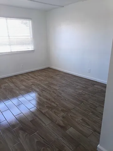 a view of a room with wooden floor and a window