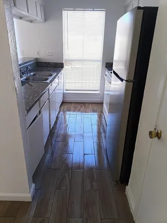 a kitchen with a sink a counter top space and cabinets