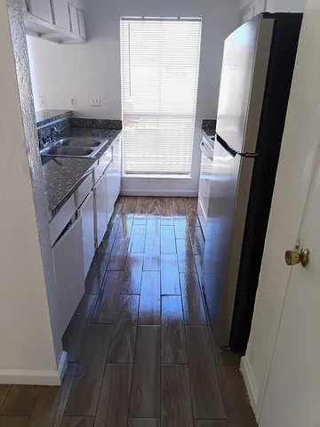 a kitchen with a sink a counter top space and cabinets