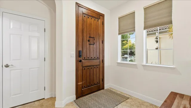 a living room with furniture and a dining table with white kitchen