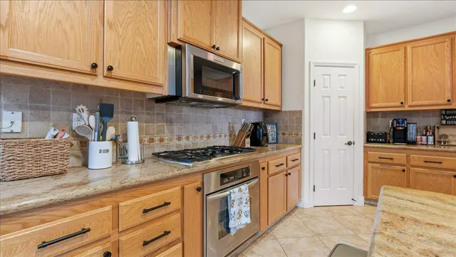 a kitchen with stainless steel appliances granite countertop a sink stove and refrigerator