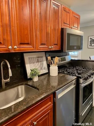 a kitchen with stainless steel appliances granite countertop a sink a stove microwave and cabinets