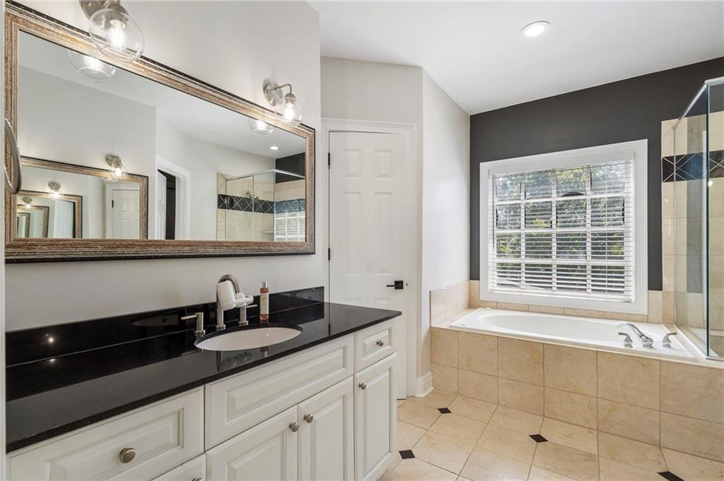 3541 Roswell Road Northeast, Unit 4 Atlanta, GA 30305 - Photo 22 of 45 a bathroom with a granite countertop sink a mirror and a bathtub
