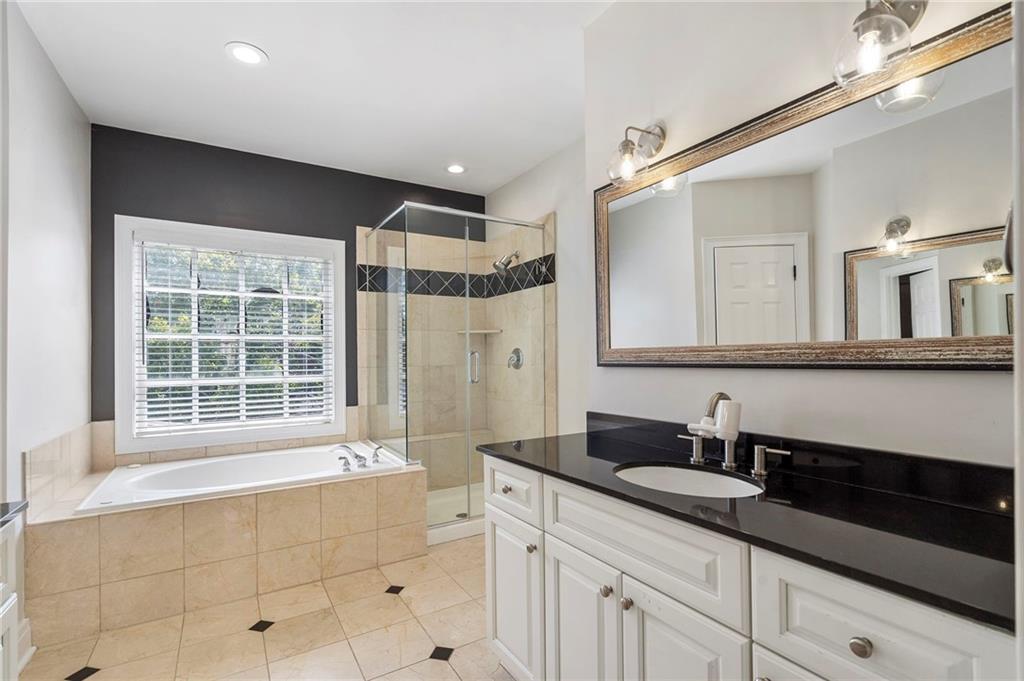 3541 Roswell Road Northeast, Unit 4 Atlanta, GA 30305 - Photo 24 of 45 a bathroom with a granite countertop sink a mirror and a bathtub